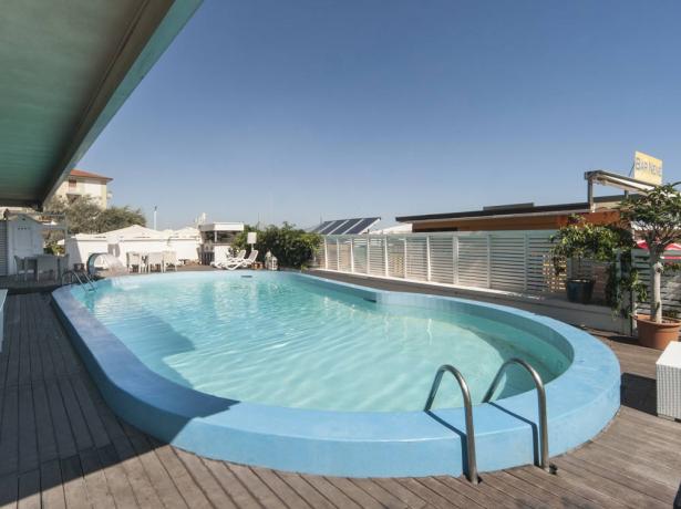 Outdoor pool with deck and lounge chairs.