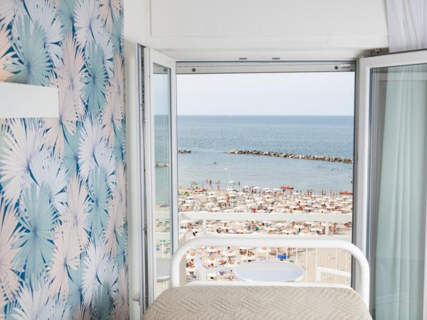 Vista mare da una camera con carta da parati tropicale.