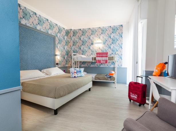 Camera luminosa e colorata con letto matrimoniale e letti a castello.
