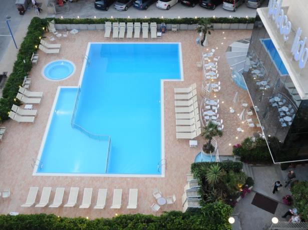 Piscina con sdraio in un hotel moderno.