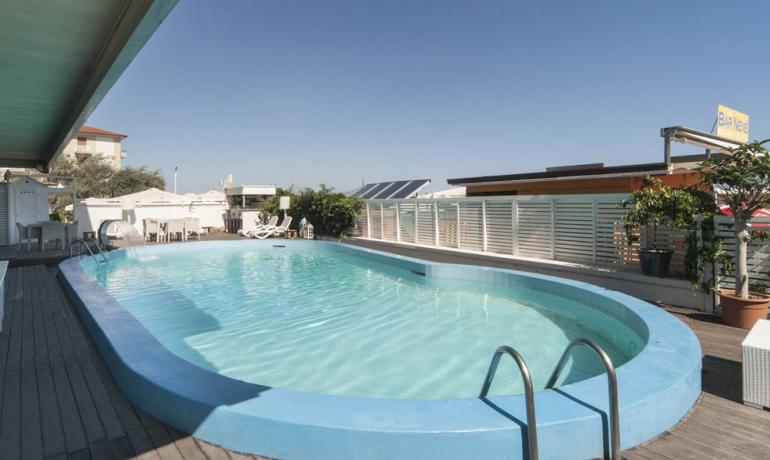 Außenpool mit Terrasse und Liegestühlen.