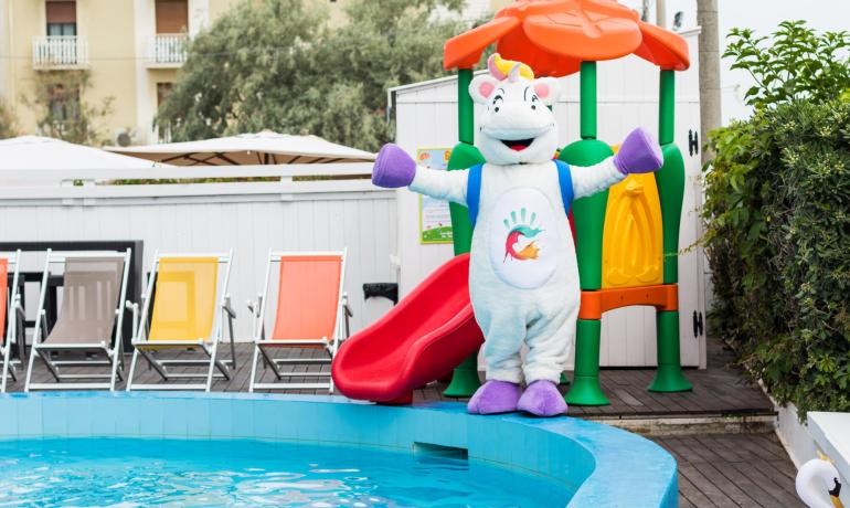Bunte Maskottchen neben einem Pool mit Rutsche.