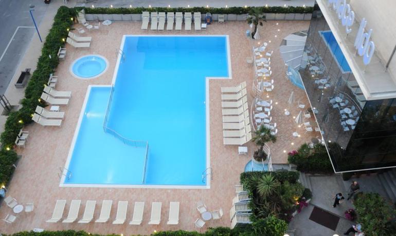 Pool mit Liegen in einem modernen Hotel.