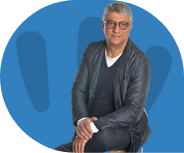 Homme assis avec lunettes, fond bleu.