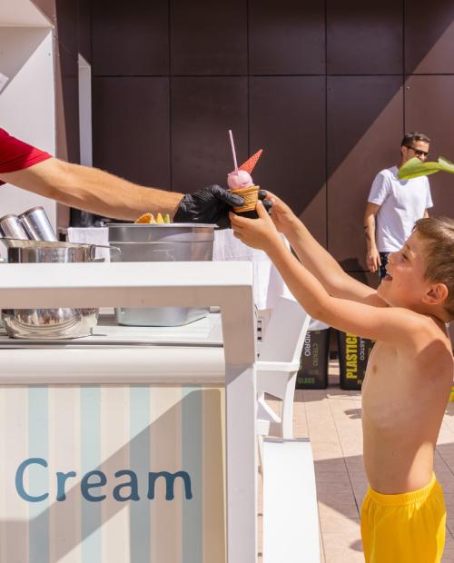 Enfants prennent de la glace à un stand extérieur.