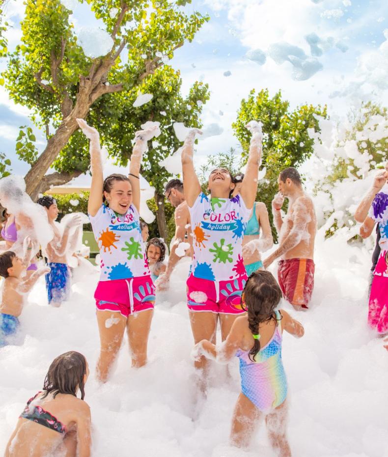 Des gens s'amusent à une fête de mousse en plein air.
