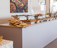 Buffet ricco di verdure, salumi e salse su un tavolo elegante.