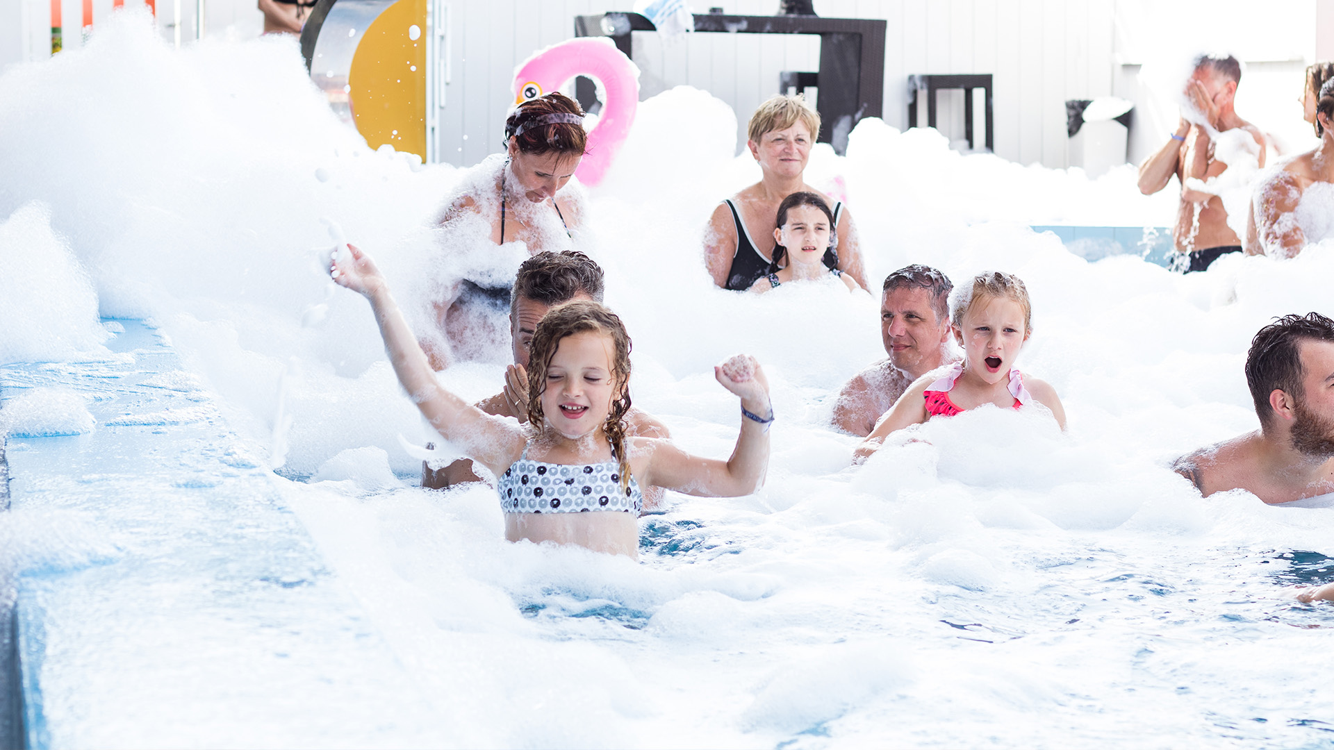 Famiglia gioca e colora insieme in un vivace ambiente per bambini.