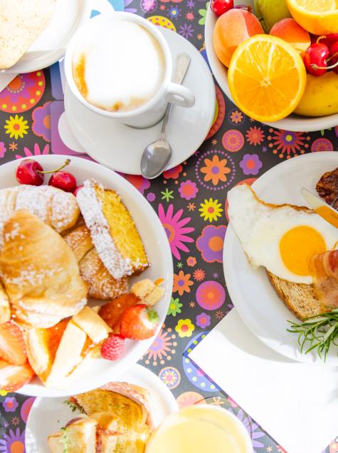 Colorful, vibrant breakfast with fruit, pastries, and coffee.