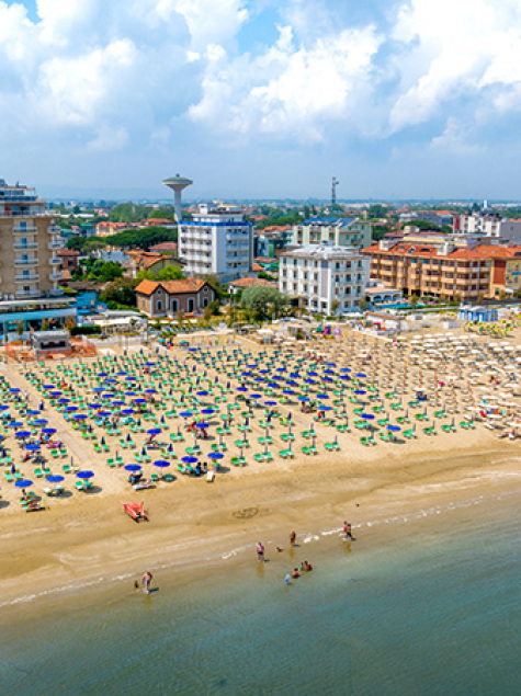 Crowded beach, colorful umbrellas, calm sea, lively summer, bustling city in the background.