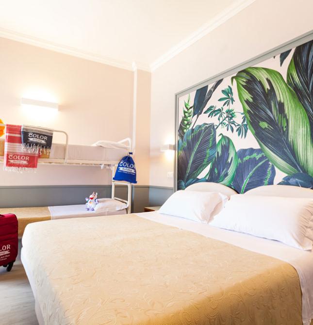 Camera luminosa con letti confortevoli e decorazioni tropicali vivaci.