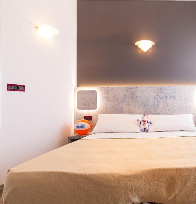 Camera luminosa con letto accogliente, decorazioni colorate e atmosfera rilassante.