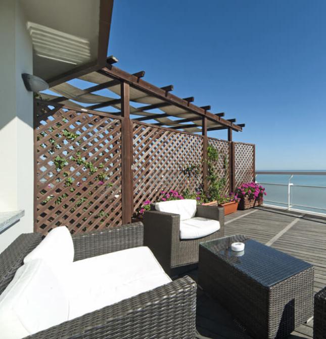 Terrazza sul mare con sedie eleganti e cielo limpido, atmosfera di relax totale.