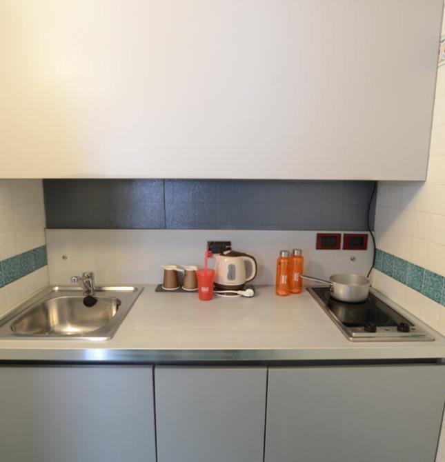 Cucina compatta, minimalista, con piastrelle colorate e atmosfera ordinata.
